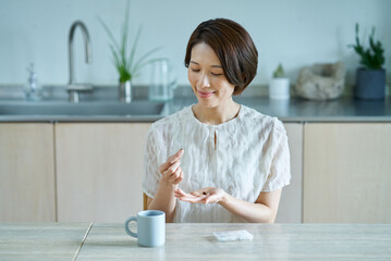 サプリメントを飲む女性