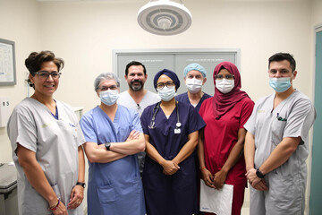 Medical team in scrubs and masks posing in a hospital setting confidently united