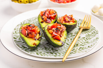 Vegan appetizers, avocados filled with bruschetta and balsamico vinaigrette