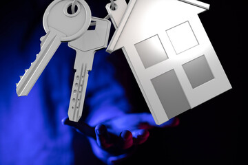 Keys and a house model on an outstretched hand. Ideal for real estate, home ownership, and property...