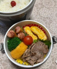 A traditional Korean dosirak, beautifully arranged with rice, assorted banchan, and savory proteins. Balanced and visually inviting, it’s a portable meal packed with vibrant flavors.