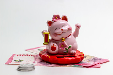 Lucky cat (Maneki-Neko) with money, isolated white background. symbolizing wealth and prosperity....