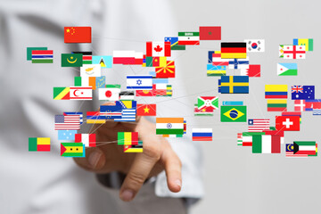 Hand interacting with a network of world flags, symbolizing global connections and international...