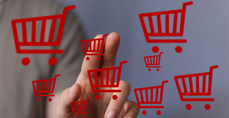 Person interacts with virtual shopping carts, symbolizing online shopping and e-commerce.