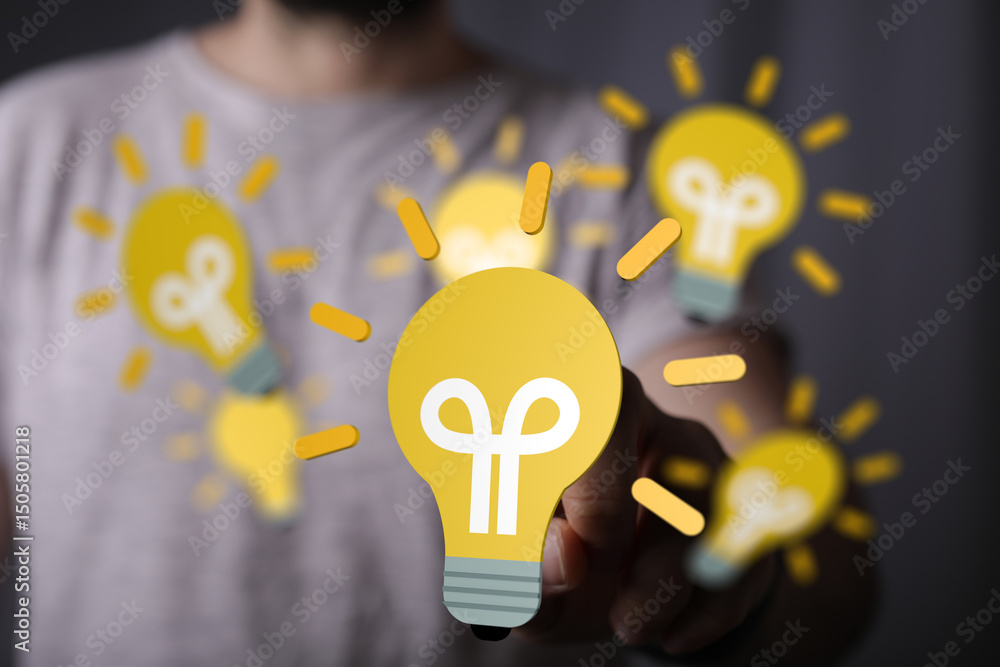 Aufkleber stock photo of a man interacting with a digital lightbulb, symbolizing innovation and new ideas.