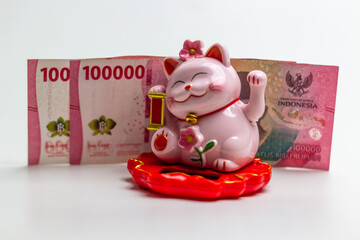 Lucky cat (Maneki-Neko) with money, isolated white background. symbolizing wealth and prosperity....