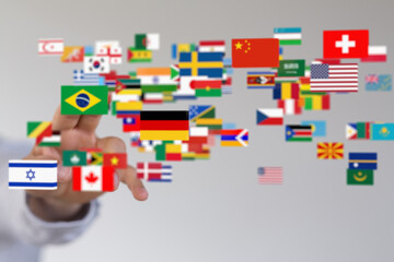 Image of a hand interacting with a digital display of numerous national flags, representing global connectivity.
