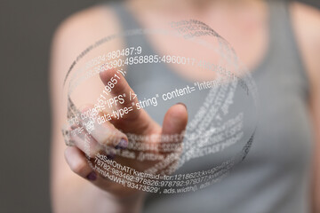 A woman interacts with a futuristic holographic sphere displaying data and code.  Technology...