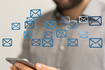 Person holding smartphone with digital email icons. Network communication concept.