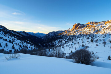 Serene Snowy Mountain Landscape Under Clear Blue Sky With Golden Sunset Glow