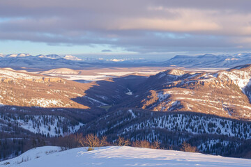 Serene Snowy Mountain Landscape with Distant Peaks Under Twilight Sky