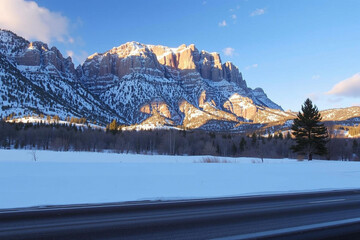 Snowy Mountain Landscape with Evergreen Trees and Roadway at Dawn
