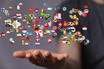 Fototapeta na wymiar Image of diverse flags floating above a hand, symbolizing global connections and international collaboration.