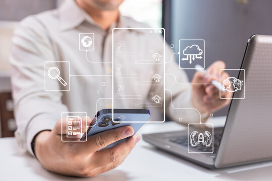 A man uses a smartphone and laptop with digital cloud computing icons overlaying the image, symbolizing modern technology and connectivity. - Powered by Adobe