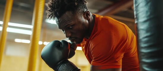 Focused boxer in orange shirt preparing for a punch.