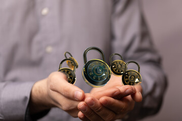 Image of hands holding multiple combination locks, symbolizing data security and protection.