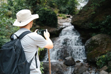 asian man taking picture while hiking