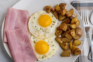   fried eggs with sliced ham and home fries