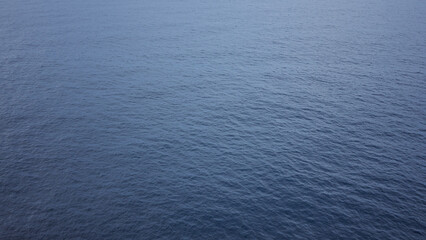 Calm ocean view shows endless expanse of deep blue water under clear sky evoking serenity and...