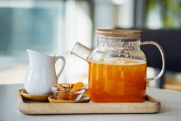 Morning breakfast with fresh tea and citrus on a wooden tray in a bright cafe