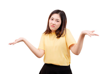 Asian young beautiful woman in a yellow shirt shrugs with both hands raised and a confused expression.