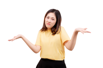 Asian young beautiful woman in a yellow shirt shrugs with both hands raised and a confused expression.