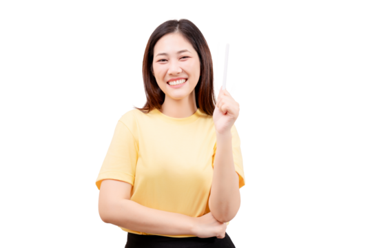 Asian young beautiful woman in a yellow shirt holds up a pen and gestures with her hand.