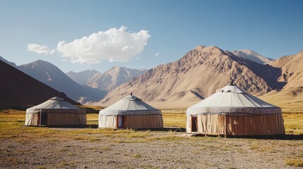 Three yurts nestled in a mountain valley landscape.