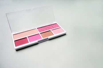 Pink eyeshadow palette resting on white surface