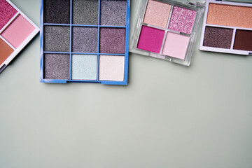Colorful eyeshadow palettes creating makeup artist's dream on pastel green background