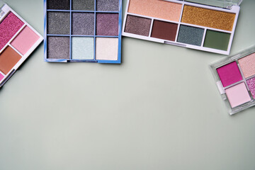 Colorful eyeshadow palettes creating makeup artist's dream on pastel background