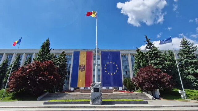 CHISINAU, MOLDOVA - MAY 21, 2025 The Moldovan Government House with the monument to the Victims of the Soviet Occupation in front of the building adorned with big EU flag on the facade