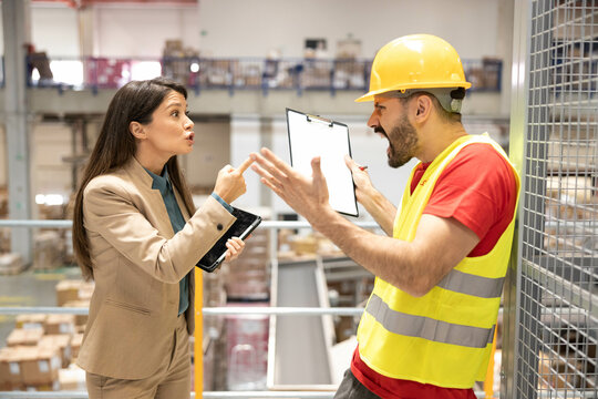 An intense discussion occurs as a manager confronts a warehouse worker over serious operational issues.