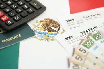 Mexican pesos money bills in big amount lies on table with pen, calculator, passport and tax forms