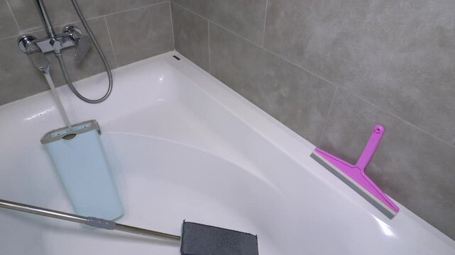  Water from the tap pours water into a bucket for washing floors, a mop with a bucket in the bathroom. Slow motion