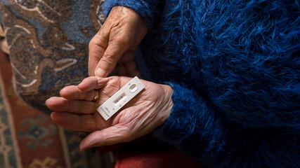 Close-up of old woman hand holding a positive test device for Covid19. © REC Stock Footage