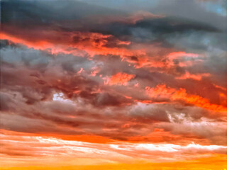 Dramatic cloudy sky in shades of gray, orange, and blue. Atmospheric, fluffy cumulus clouds, a beautiful landscape. Natural texture, background. Sunset. Full screen. Space for text with a beautiful ba