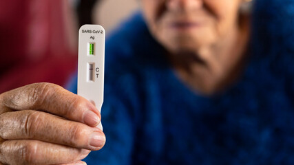 Close-up of old woman hand holding a negative test device for Covid19.