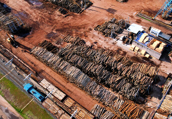 Timber warehouse on Timber plant, drone view. Woodworking plant, Wood processing industry. Storage of stacked timber in timber processing plant, aerial view. Warehouse lumber, industrial logging.