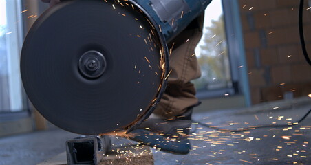 Rotating angle grinder emitting sparks during metalwork, construction worker using power tool in industrial project, super slow motion