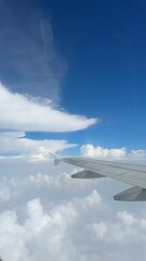 vertical photos Airplane wing clouds Wing of the plane on blue sky background