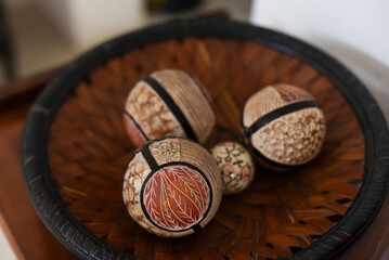 Carved wooden balls, decorative balls in a wicker basket, rustic decor, design and architecture, balls wooden close up
