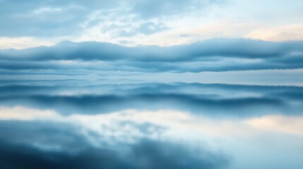 Obraz premium Serene Horizon with Peaceful Clouds and Mirror-Like Water Reflections at Dusk in Soft Blue Tones for Tranquil Imagery and Calming Atmosphere
