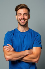 Fototapeta premium A happy individual wearing a blue shirt and crossing his arms, perfect for depicting joy or relaxation