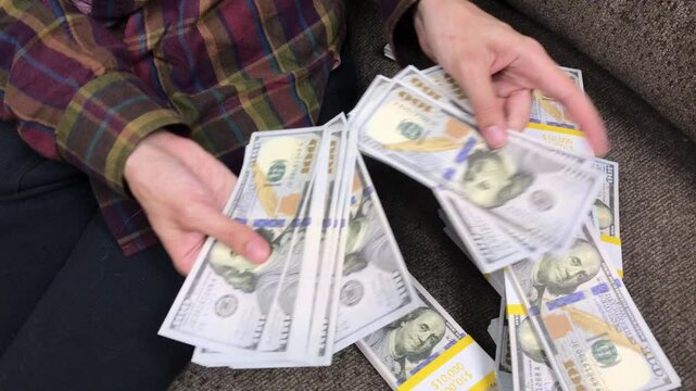 Young Woman Counts Stacks of Cash $100 Bills