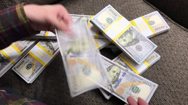 Young Woman Counts Stacks of Cash $100 Bills