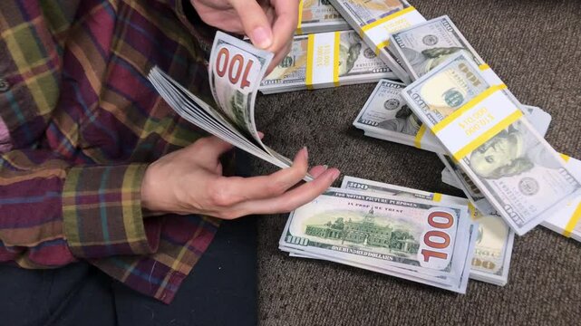 Young Woman Counts Stacks of Cash $100 Bills