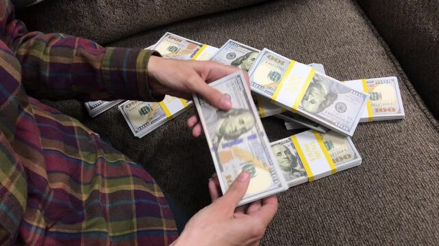 Young Woman Counts Stacks of Cash $100 Bills