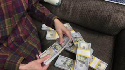 Young Woman Counts Stacks of Cash $100 Bills