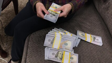 Young Woman Counts Stacks of Cash $100 Bills